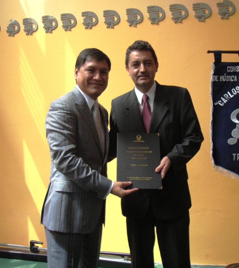 Congresista Alberto Escudero Casquino entregando el texto de la Ley 29595 al Director General del Conservatorio Mg. Carlos Paredes Abad, mediante la cual se obtiene el Rango Universitario.
